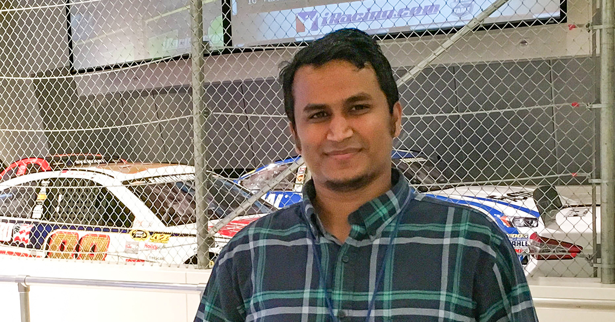 Shahed Sorower, Capital One data scientist, stands in front of a NASCAR racecar